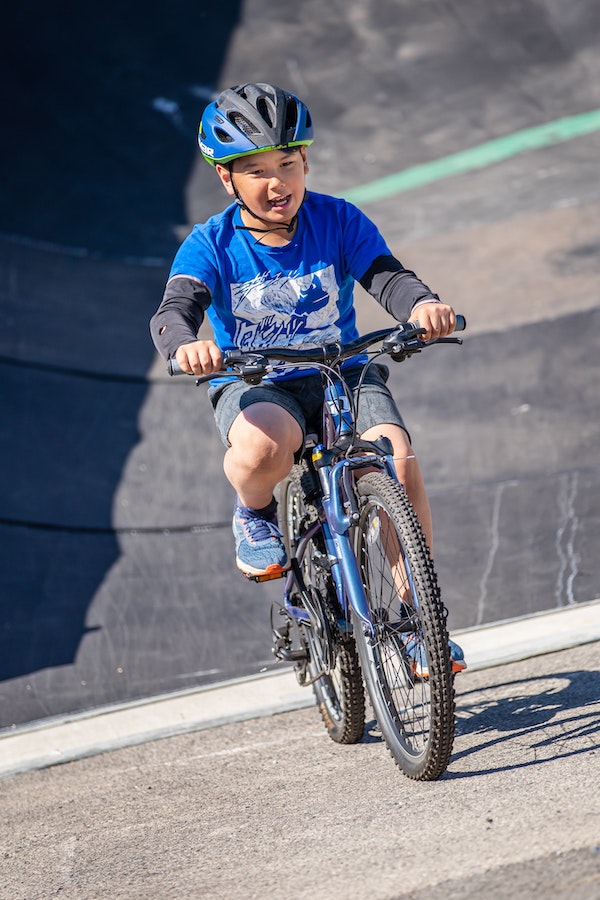 young boy balancing on and riding a bicycle